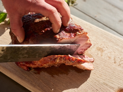 Hands Cutting Meat From BBQ